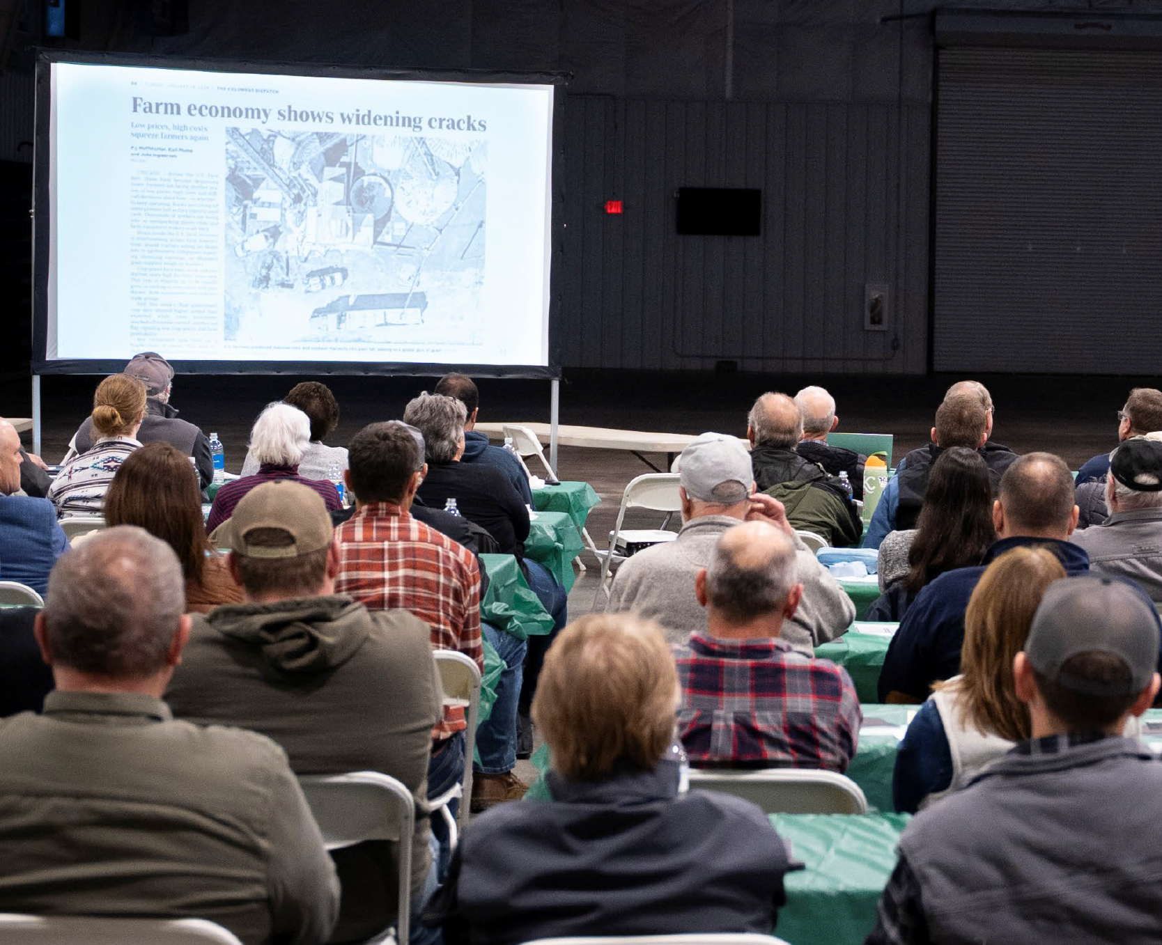 Residents seated at a community meeting watching a presentation